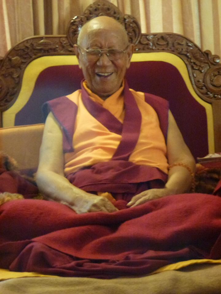 Kyabje Khensur Kangyurwa Rinpoche, laughing, seated on a carved teaching throne